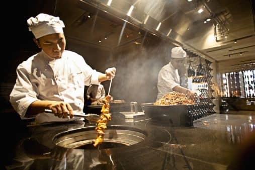 Un cuisinier au travail devant le tandoor