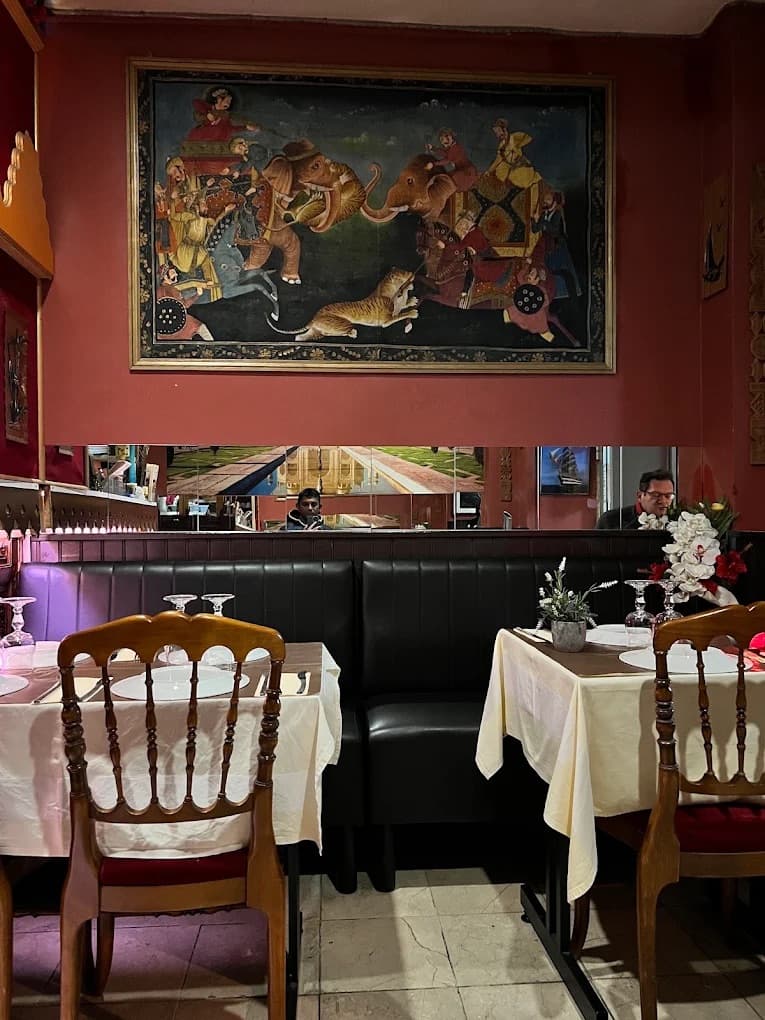 Banquettes, nappes blanches et tableau au mur dans la salle